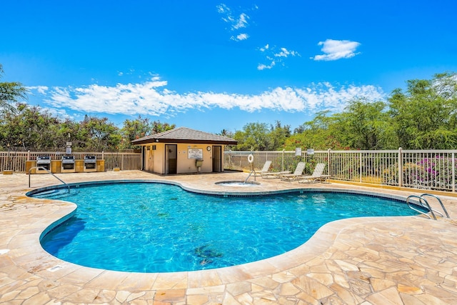 pool featuring fence, exterior kitchen, and a patio area