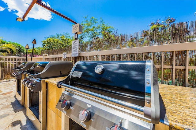 view of patio featuring fence and a grill