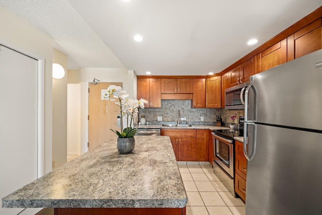 kitchen with decorative backsplash, light tile patterned flooring, a center island, a sink, and stainless steel appliances