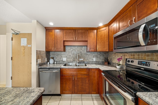 kitchen featuring a sink, tasteful backsplash, light tile patterned flooring, and stainless steel appliances