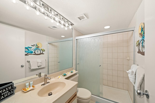 bathroom featuring vanity, toilet, visible vents, and a stall shower