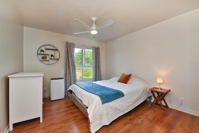 bedroom with baseboards, wood finished floors, and a ceiling fan