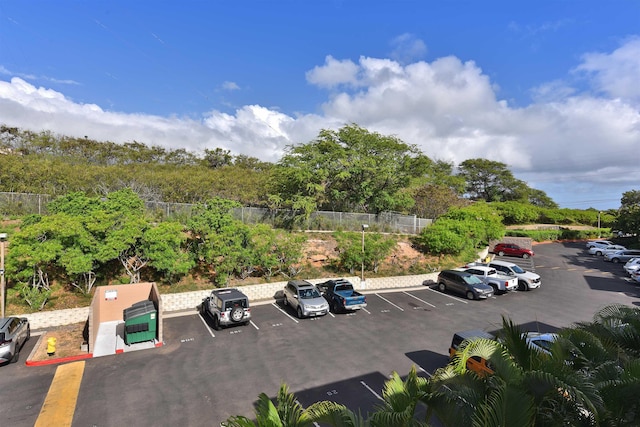 uncovered parking lot featuring fence