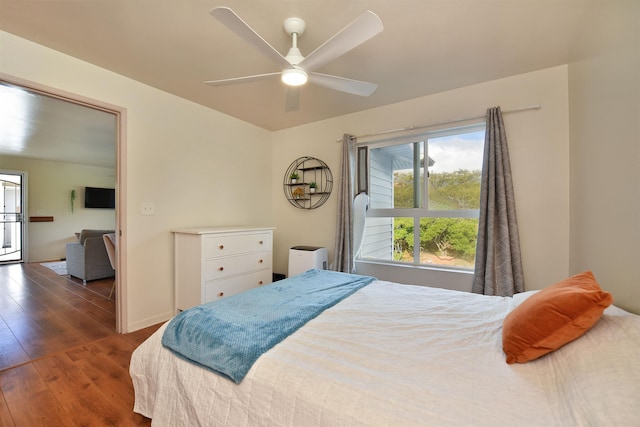 bedroom with ceiling fan, baseboards, and wood finished floors