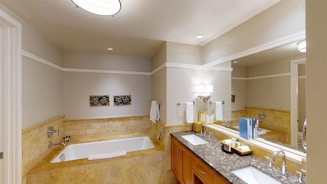 bathroom with double vanity, a bath, and a sink