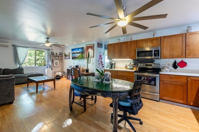 kitchen featuring light hardwood / wood-style floors, ceiling fan, backsplash, and appliances with stainless steel finishes