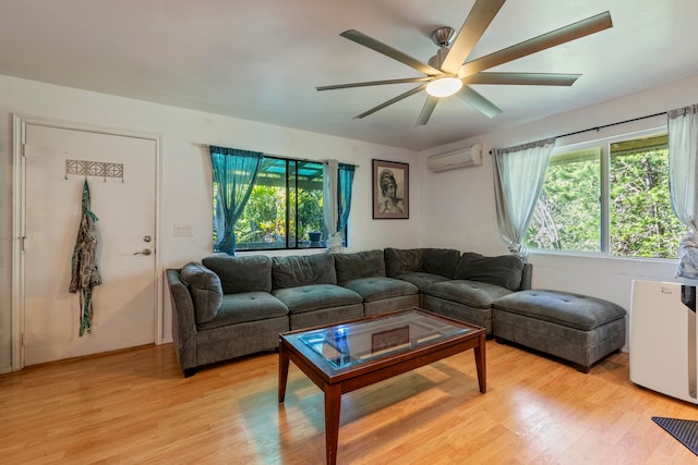 living room with light wood-type flooring, ceiling fan, and a wall mounted AC