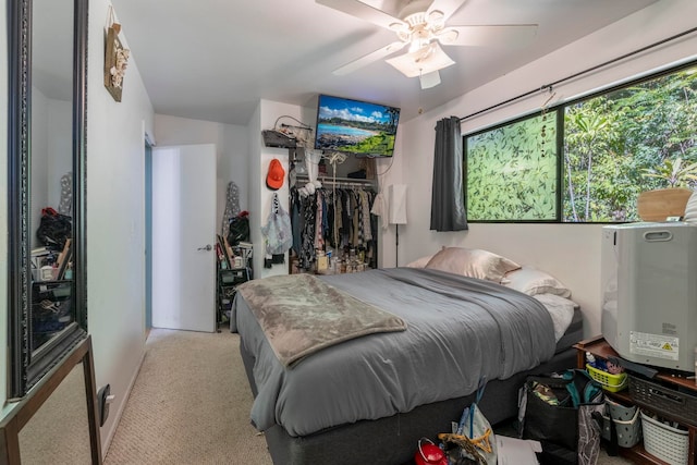 bedroom featuring a closet, light colored carpet, and ceiling fan