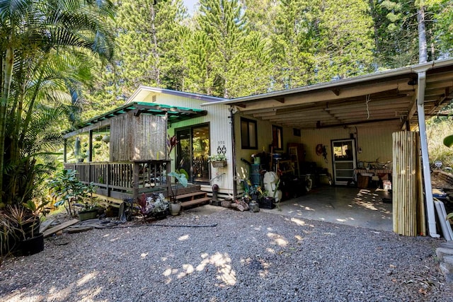 rear view of house featuring a carport and a deck