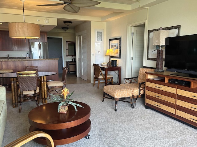 living area featuring carpet and a ceiling fan