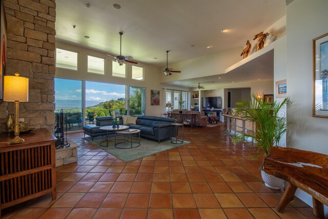 tiled living room featuring ceiling fan and a towering ceiling