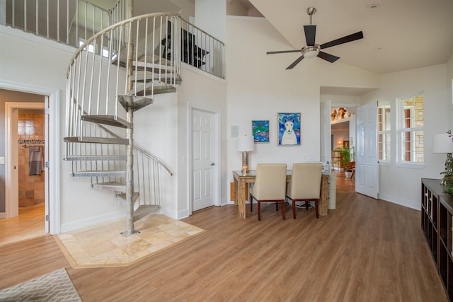 interior space with ceiling fan, wood-type flooring, and high vaulted ceiling