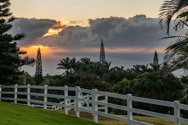 yard at dusk featuring a water view