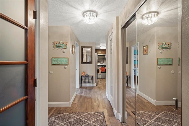 hall featuring hardwood / wood-style floors and an inviting chandelier