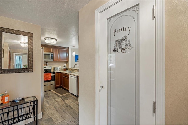 hall featuring a textured ceiling and sink