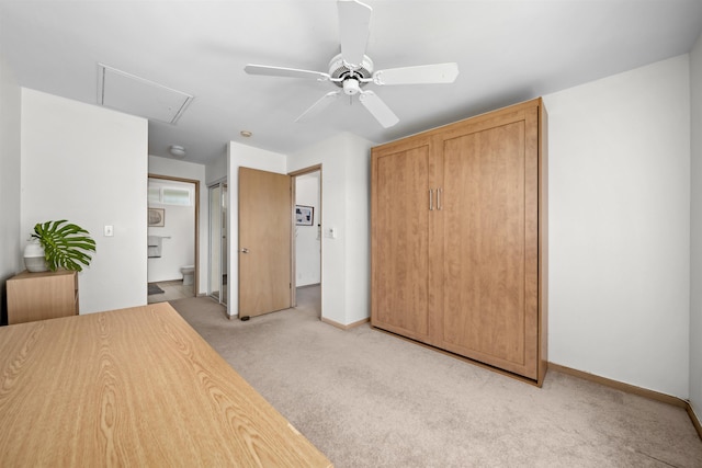 unfurnished bedroom with ceiling fan, ensuite bathroom, and light carpet