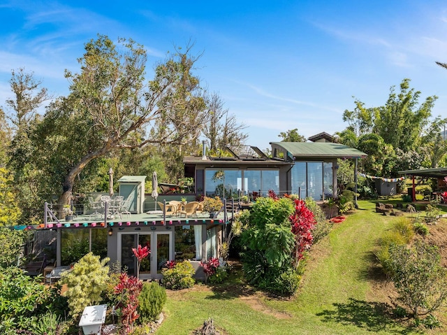 rear view of property featuring a lawn