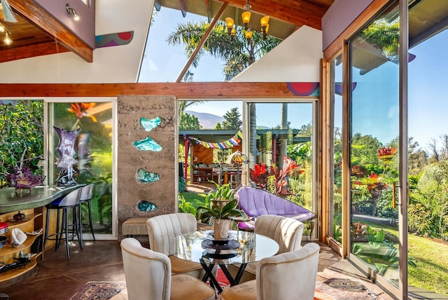 sunroom featuring a chandelier and lofted ceiling with beams