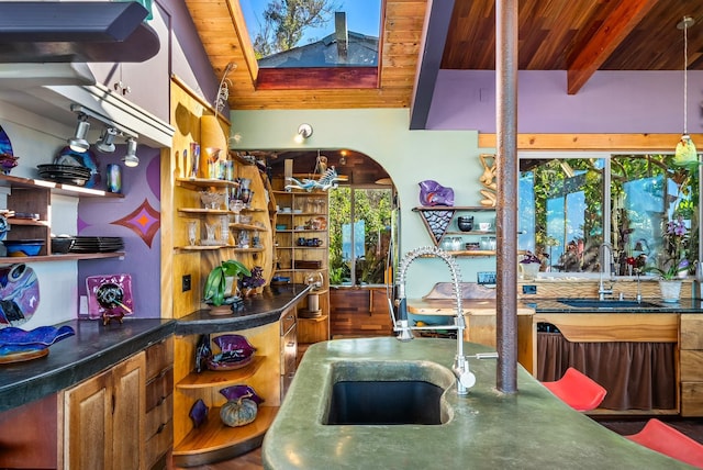 kitchen with beam ceiling, hardwood / wood-style flooring, wooden ceiling, and sink