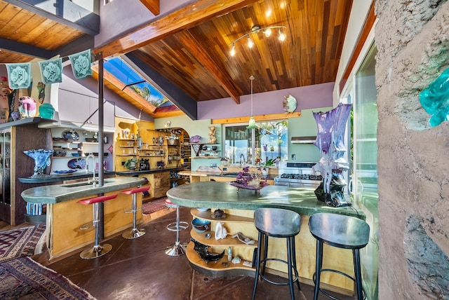 kitchen with dark tile patterned flooring, sink, vaulted ceiling with skylight, stainless steel range, and wood ceiling