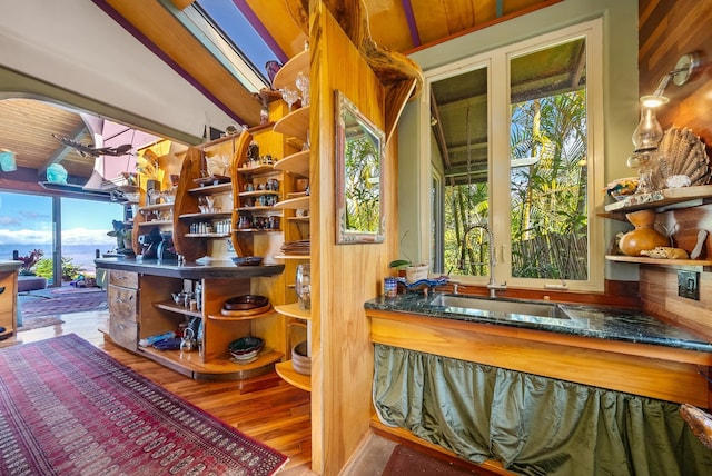 bar featuring vaulted ceiling with skylight, sink, wooden ceiling, and hardwood / wood-style flooring