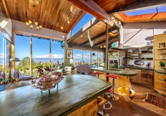 dining room with sink, wooden ceiling, a notable chandelier, vaulted ceiling with skylight, and light wood-type flooring