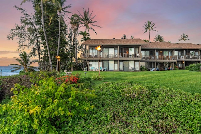 3975 Lower Honoapiilani Rd Unit 107, Lahaina, HI 96761 - back of property at dusk featuring a lawn and a water view