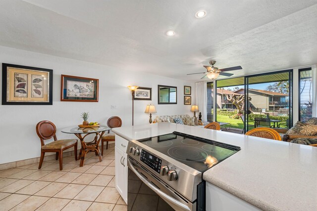3975 Lower Honoapiilani Rd Unit 107, Lahaina, HI 96761 - kitchen featuring stainless steel electric range, light tile patterned floors, light countertops, white cabinetry, and a ceiling fan