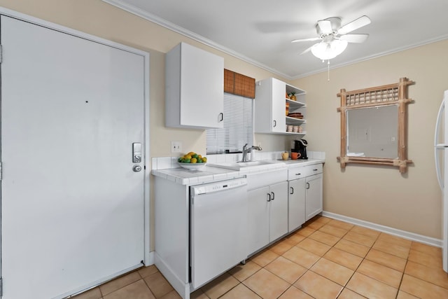 kitchen with white dishwasher, white cabinetry, tile counters, and ornamental molding