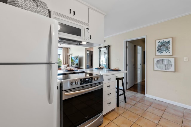 kitchen featuring white appliances, white cabinetry, ornamental molding, and light tile patterned flooring