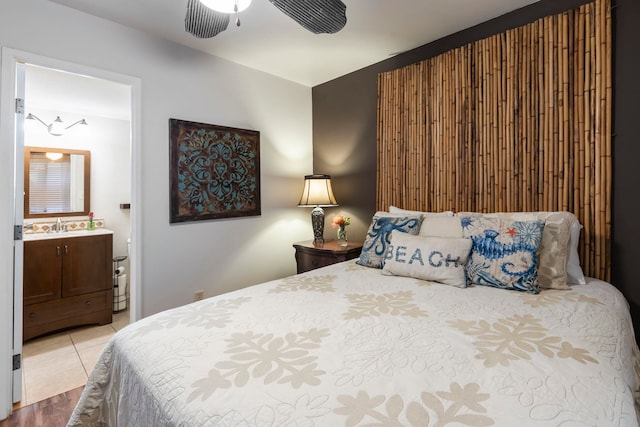 bedroom with ceiling fan, wood-type flooring, sink, and ensuite bath