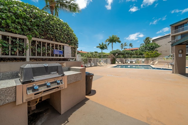 view of pool with grilling area and a patio area