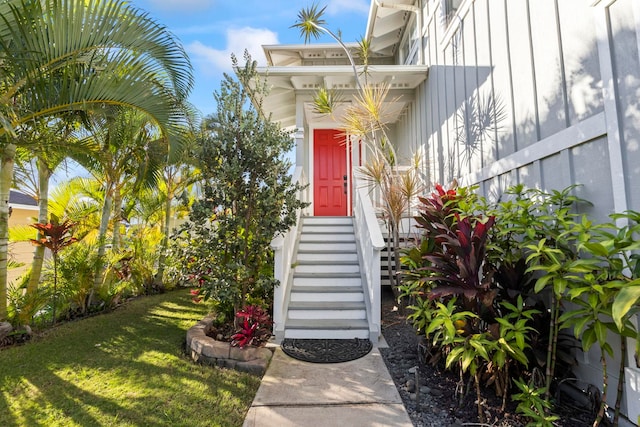 property entrance featuring a yard and board and batten siding