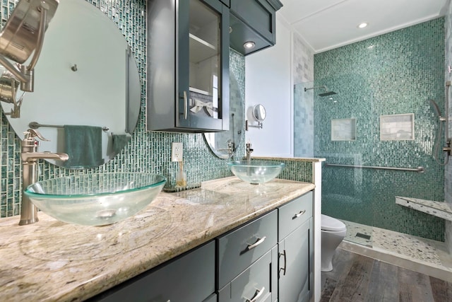 full bathroom featuring toilet, backsplash, a walk in shower, and wood finished floors