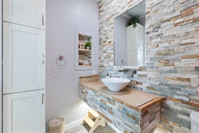 bathroom with tasteful backsplash, a sink, and crown molding