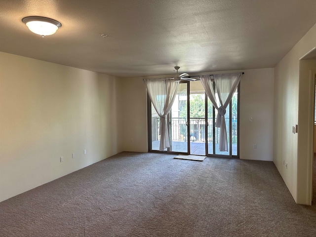 carpeted spare room featuring ceiling fan and a textured ceiling