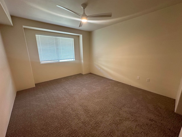 carpeted spare room with ceiling fan