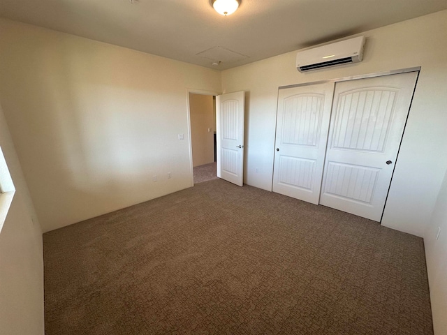 unfurnished bedroom featuring a wall mounted air conditioner, dark carpet, and a closet