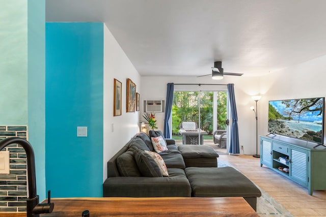 living room with light wood-type flooring, a ceiling fan, and a wall mounted air conditioner