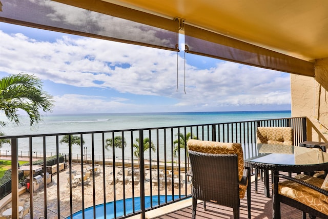 balcony featuring a water view and a beach view