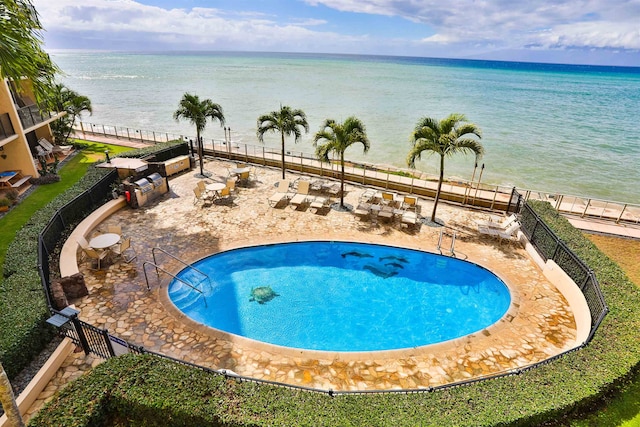 view of swimming pool featuring a patio and a water view