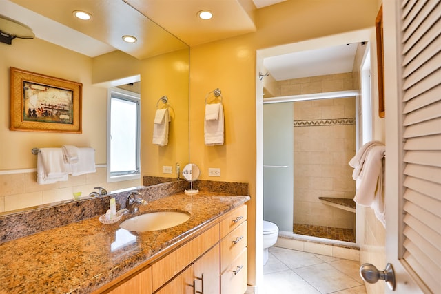 bathroom featuring toilet, walk in shower, vanity, and tile patterned floors