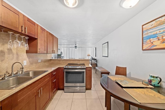 111 Kahului Beach Rd Unit D306, Kahului, HI 96732 - kitchen with stainless steel range with electric stovetop, a sink, a peninsula, light tile patterned floors, and light countertops