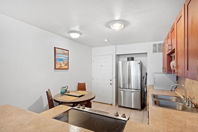 111 Kahului Beach Rd Unit D306, Kahului, HI 96732 - kitchen featuring freestanding refrigerator, a sink, light tile patterned floors, range, and brown cabinetry