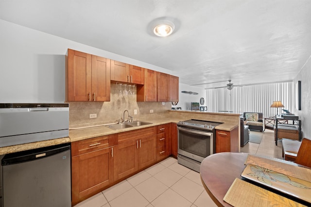 111 Kahului Beach Rd Unit D306, Kahului, HI 96732 - kitchen featuring appliances with stainless steel finishes, a peninsula, light countertops, a sink, and light tile patterned floors