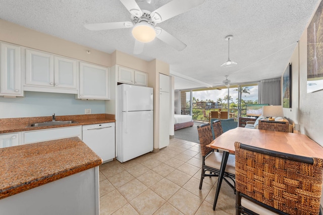 kitchen with white appliances, ceiling fan, white cabinets, and sink