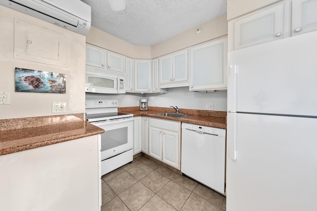 kitchen with white cabinets, a textured ceiling, white appliances, sink, and light tile flooring