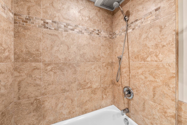 room details with tiled shower / bath combo