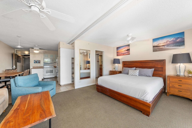 bedroom featuring ceiling fan, light carpet, and a textured ceiling