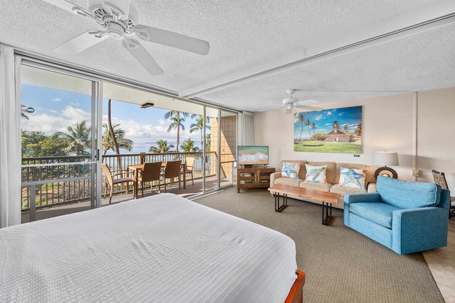 carpeted bedroom featuring floor to ceiling windows, a textured ceiling, ceiling fan, and multiple windows